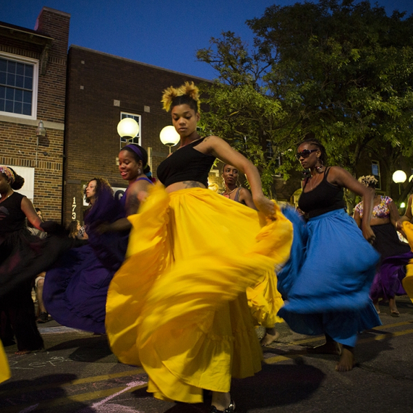 A group of dancers in bright yellow and blue skirts