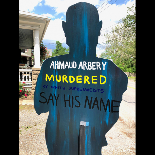 A cardboard cut out with the words "Ahmaud Arbery. Murdered. Say His Name."